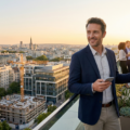 Un homme d'affaires souriant sur un toit à Paris, tenant un smartphone avec des lignes lumineuses glowing de réseau reliant les bâtiments pour des transactions immobilières.
